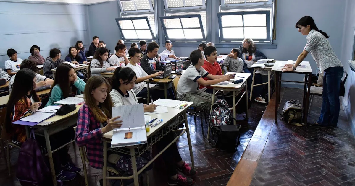 Docente y estudiantes trabajan en un aula argentina.