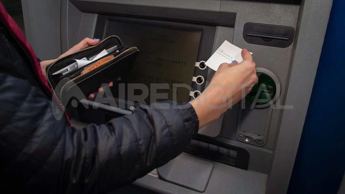 Dinero en efectivo dispuesto junto a un cajero automático.